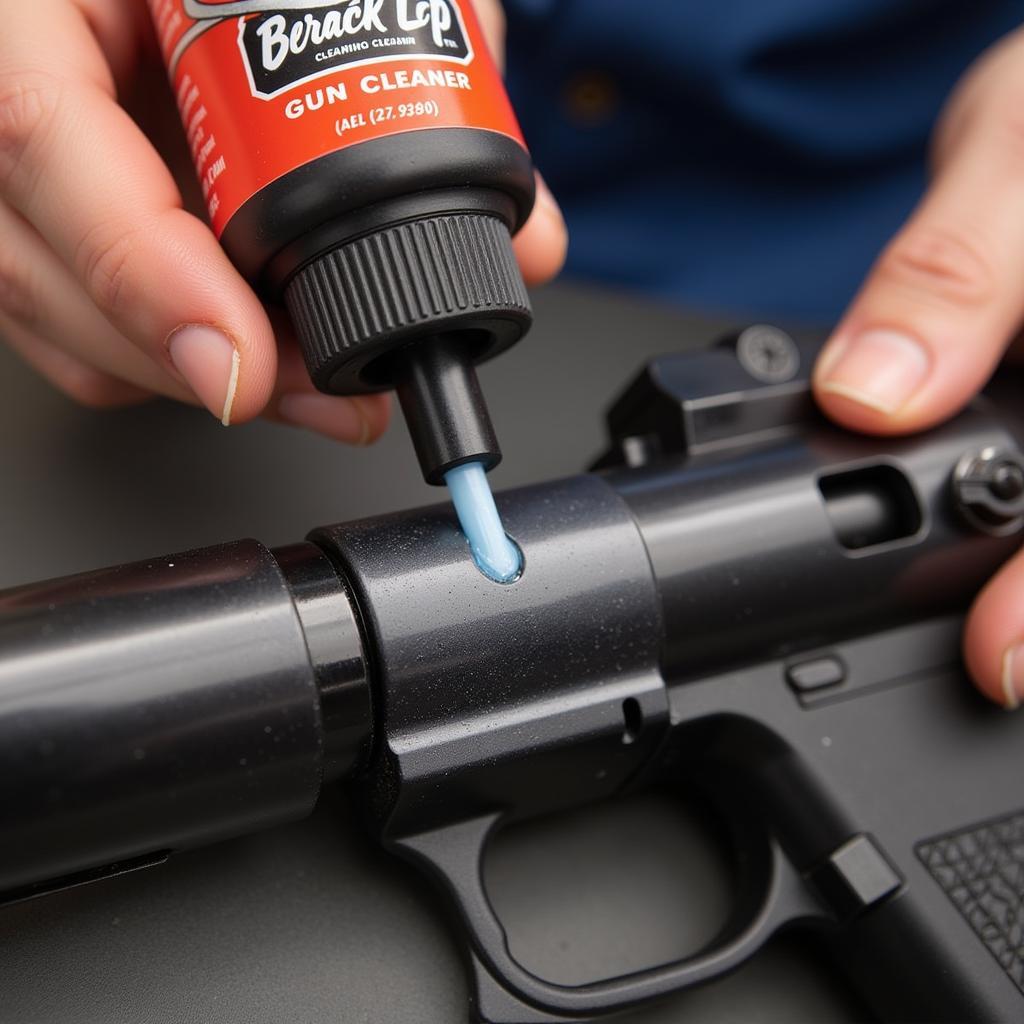 Applying Break Free CLP gun cleaner to a firearm's slide and barrel