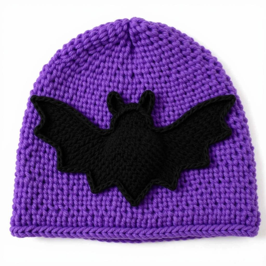 A finished crochet bat applique attached to a purple knitted hat.