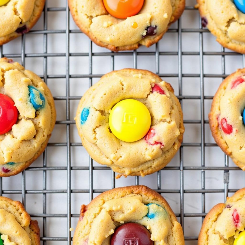 Freshly baked gluten-free M&M cookies cooling on a wire rack.