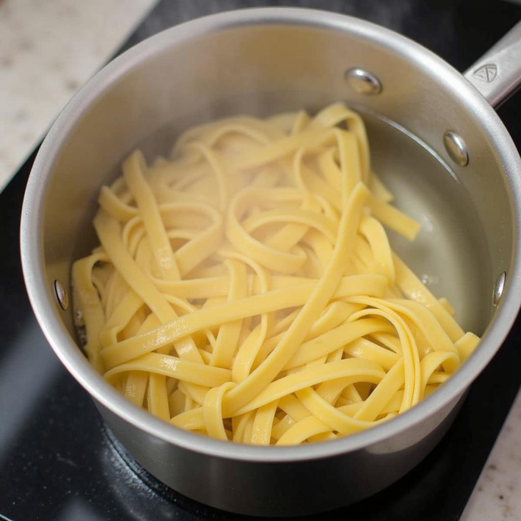 Gluten free pappardelle cooking in boiling water