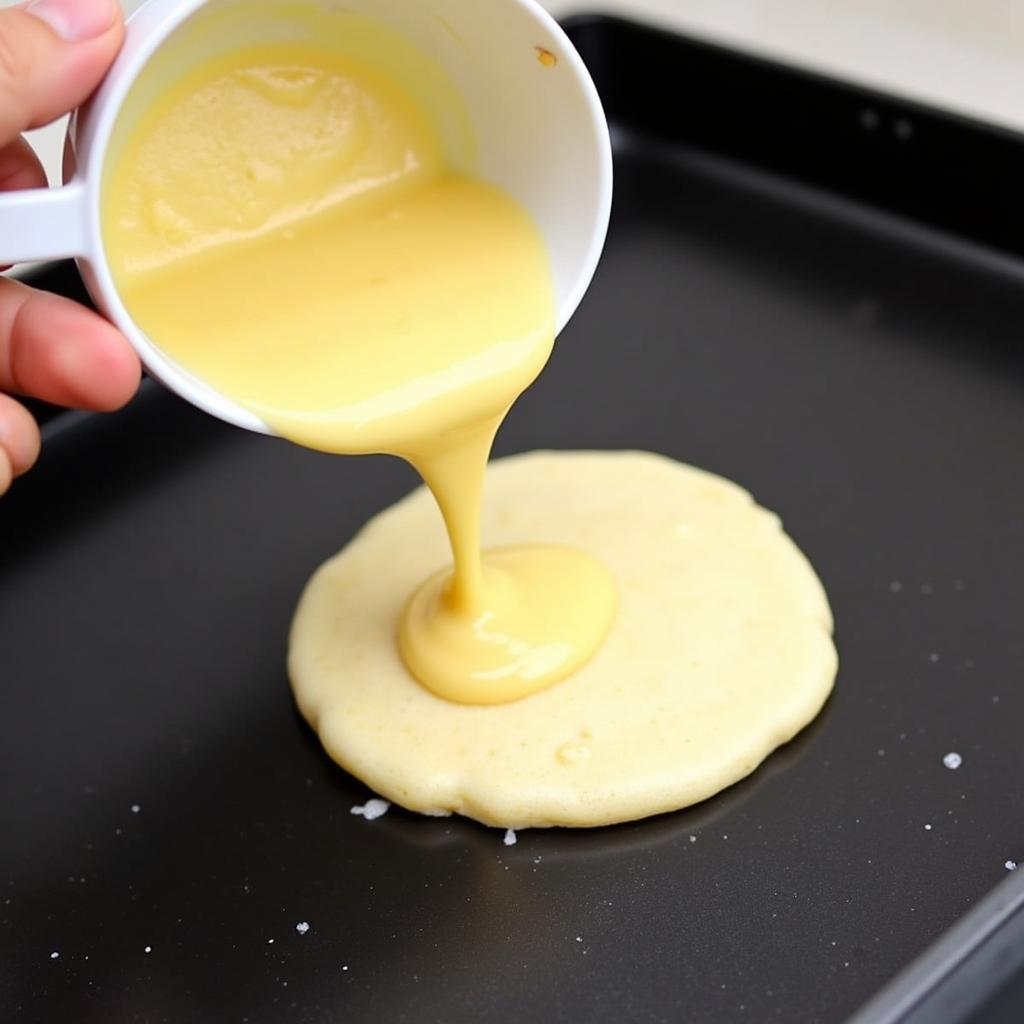 Pouring pancake batter onto a griddle