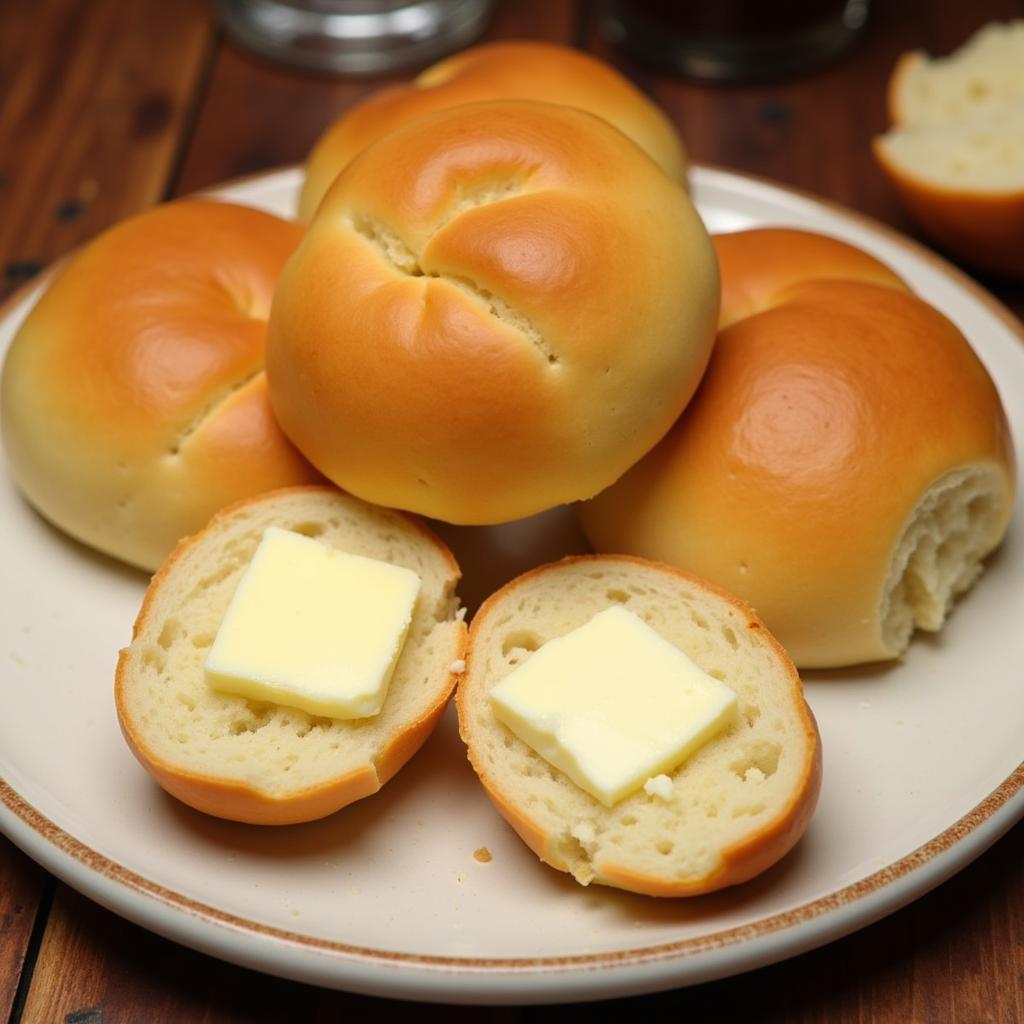 A plate of warm, freshly baked gluten-free dinner rolls with butter.