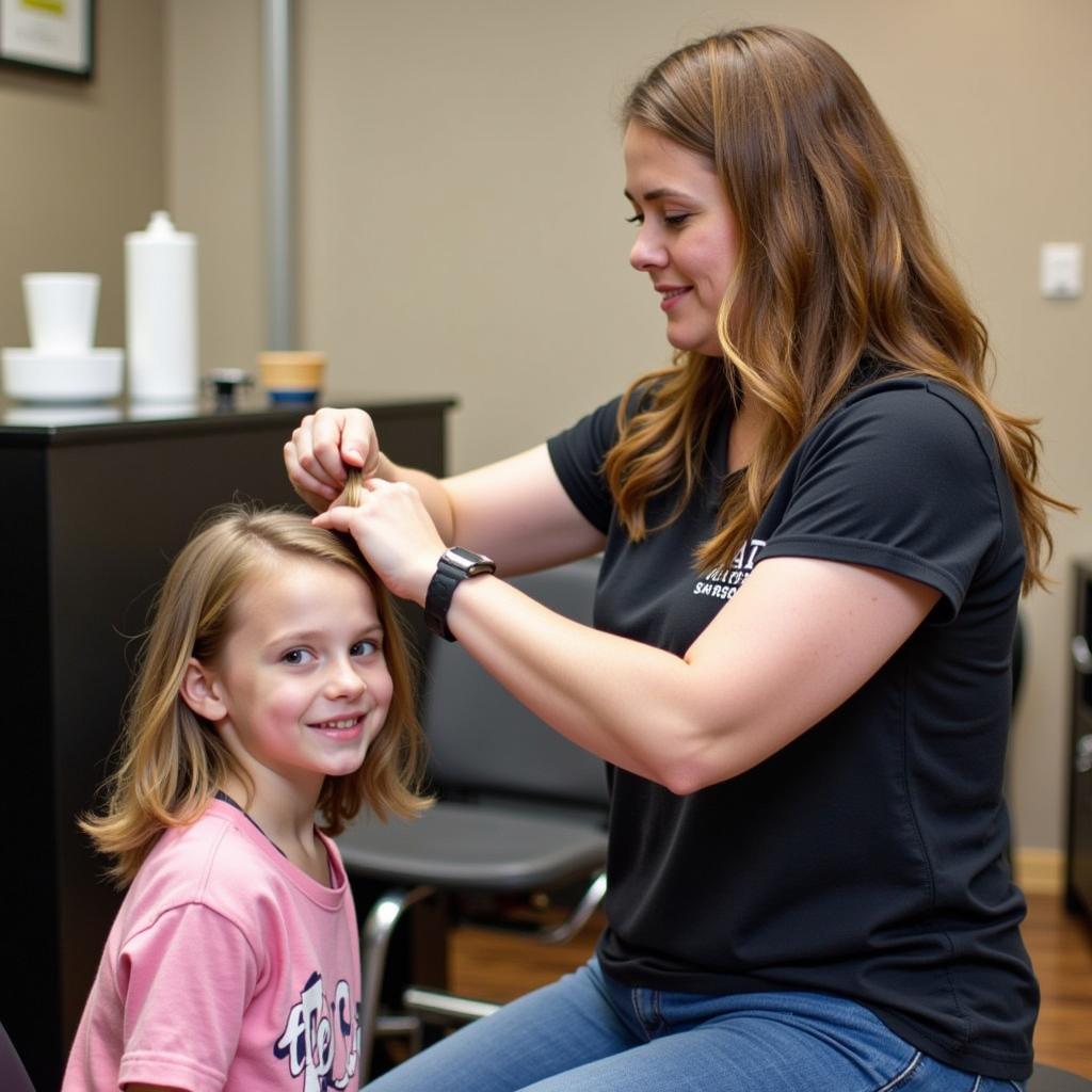 A child getting a free haircut from a volunteer stylist.